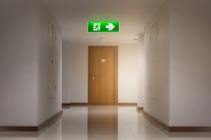 Emergency lighting sign lit above an emergency exit door