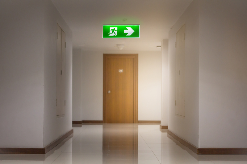 Emergency lighting sign lit above an emergency exit door
